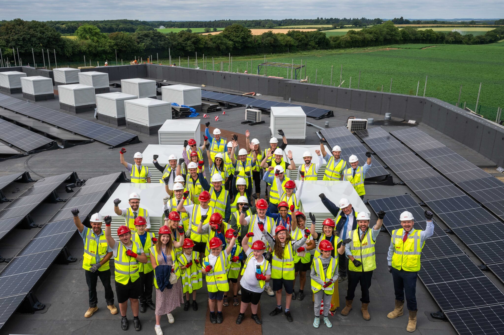 Pupils and representatives from R G Carter, NPS and Norfolk County Council on the new roof at the Fred Nicholson School